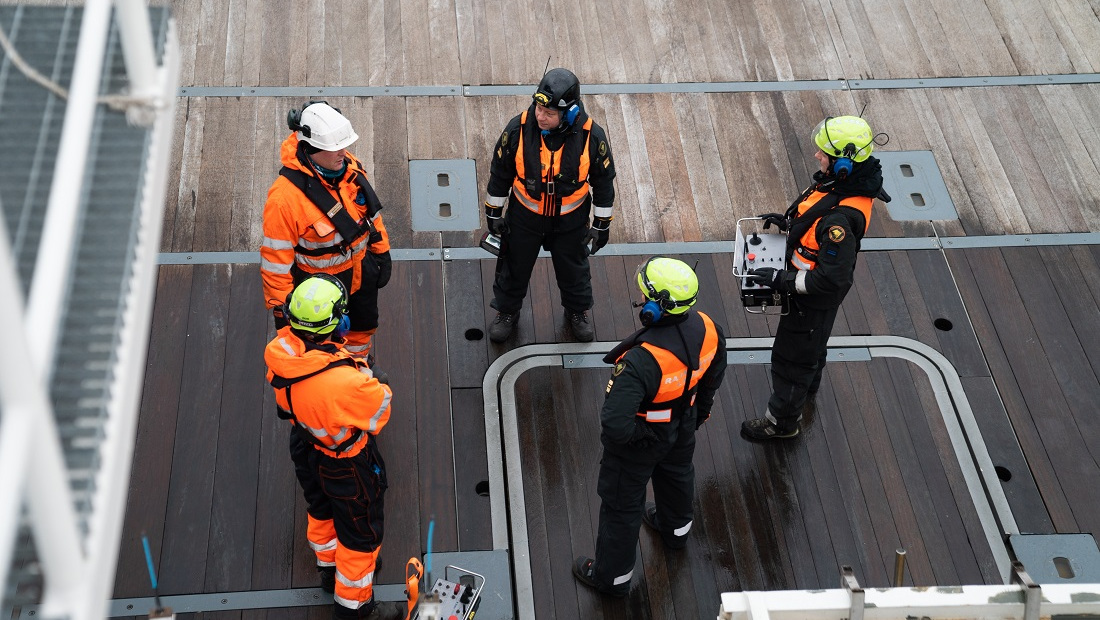 Pelastajia ja merivartioita laivan kannella.