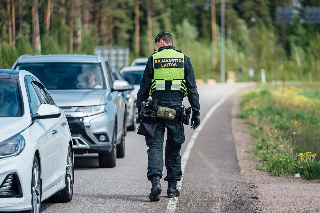 Rajavartija kävelee autojonon vieressä.