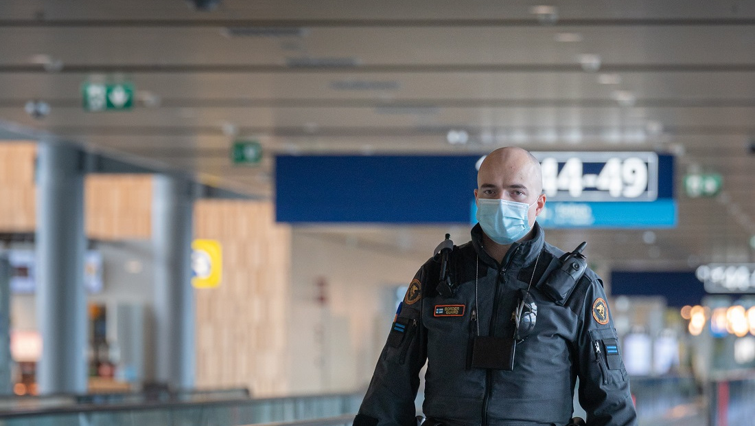 Rajavartija lentoasemalla hengityksensuojain kasvoilla.