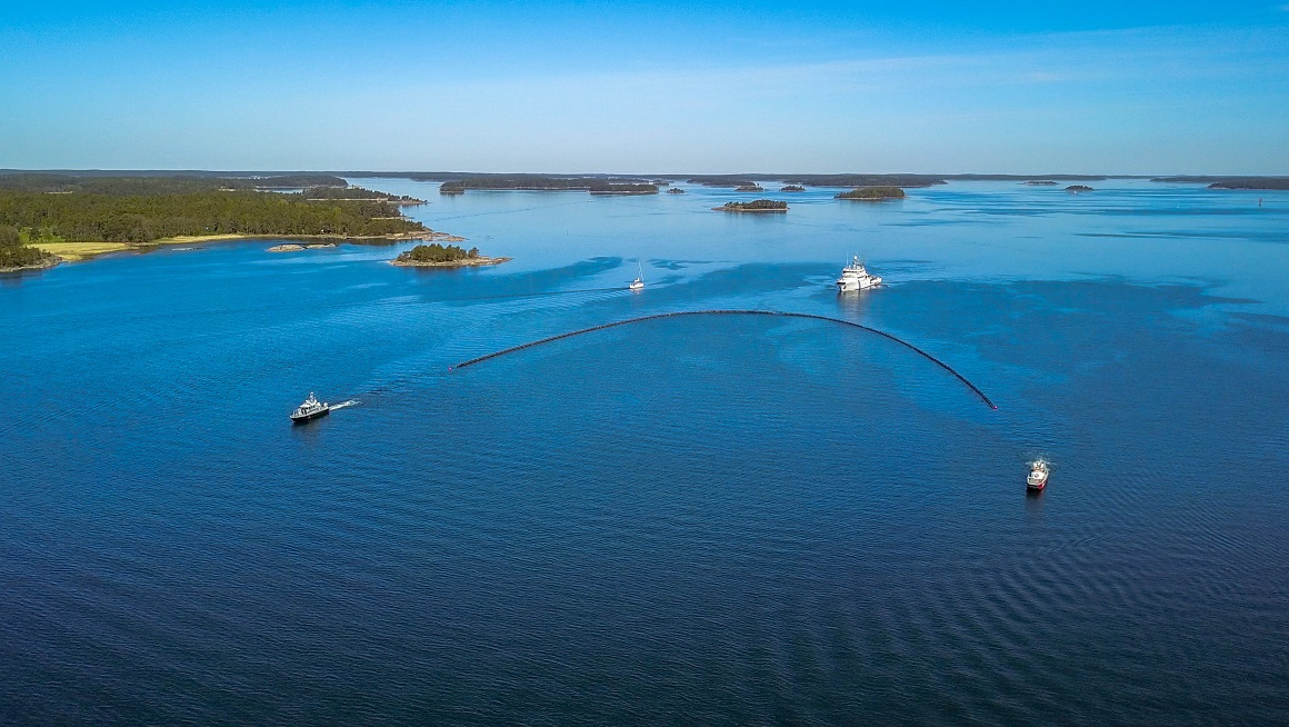 Öljyntorjuntapuomi ja aluksia lähellä saaristoa.