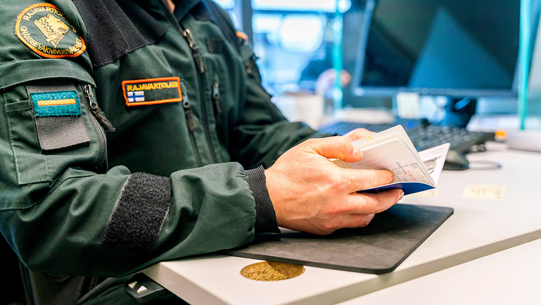 Rajavartija tarkastaa matkustusasiakirjoja.