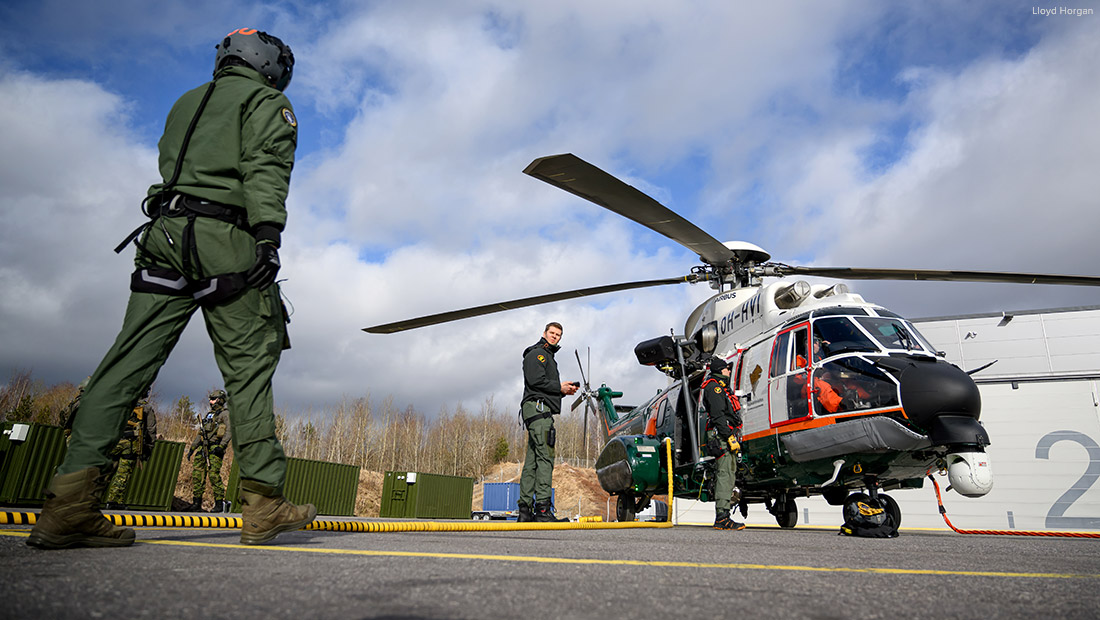 Rajavartiolaitoksen Vartiolentolaivueen työntekijä kävelee kohti helikopteria.