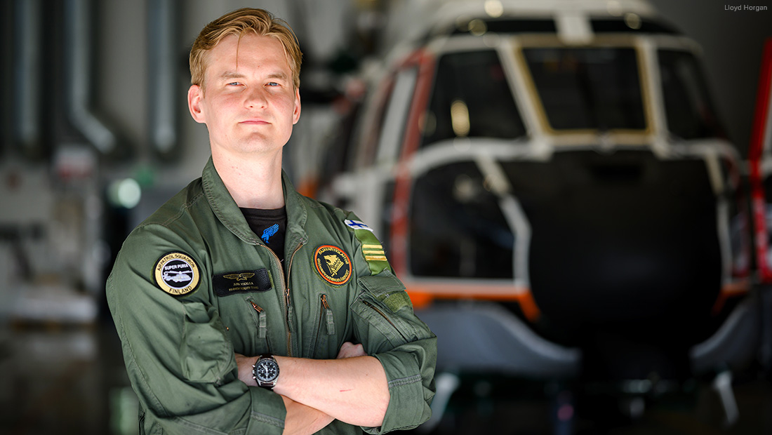 Rajavartiolaitoksen Vartiolentolaivueen työntekijä seisoo helikopterihallissa.