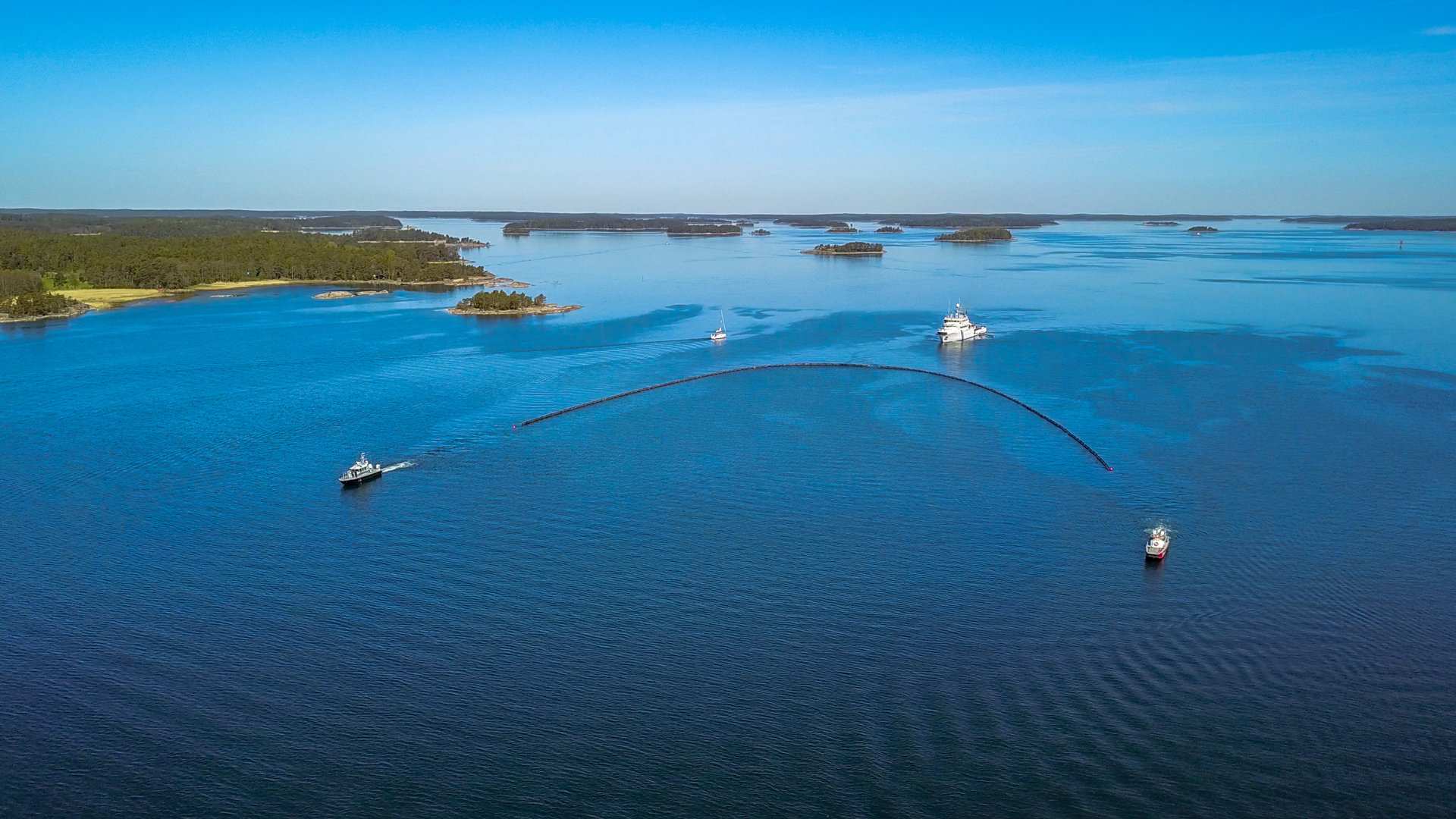 Öljyntorjuntaharjoitus, jossa vartioalus vetää öljypuomia merellä.