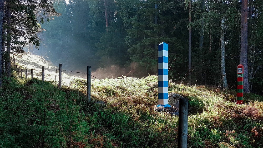 Suomen sinivalkoinen ja venäjän vihreä-punainen rajapaalu valton rajavyöhykkeellä.