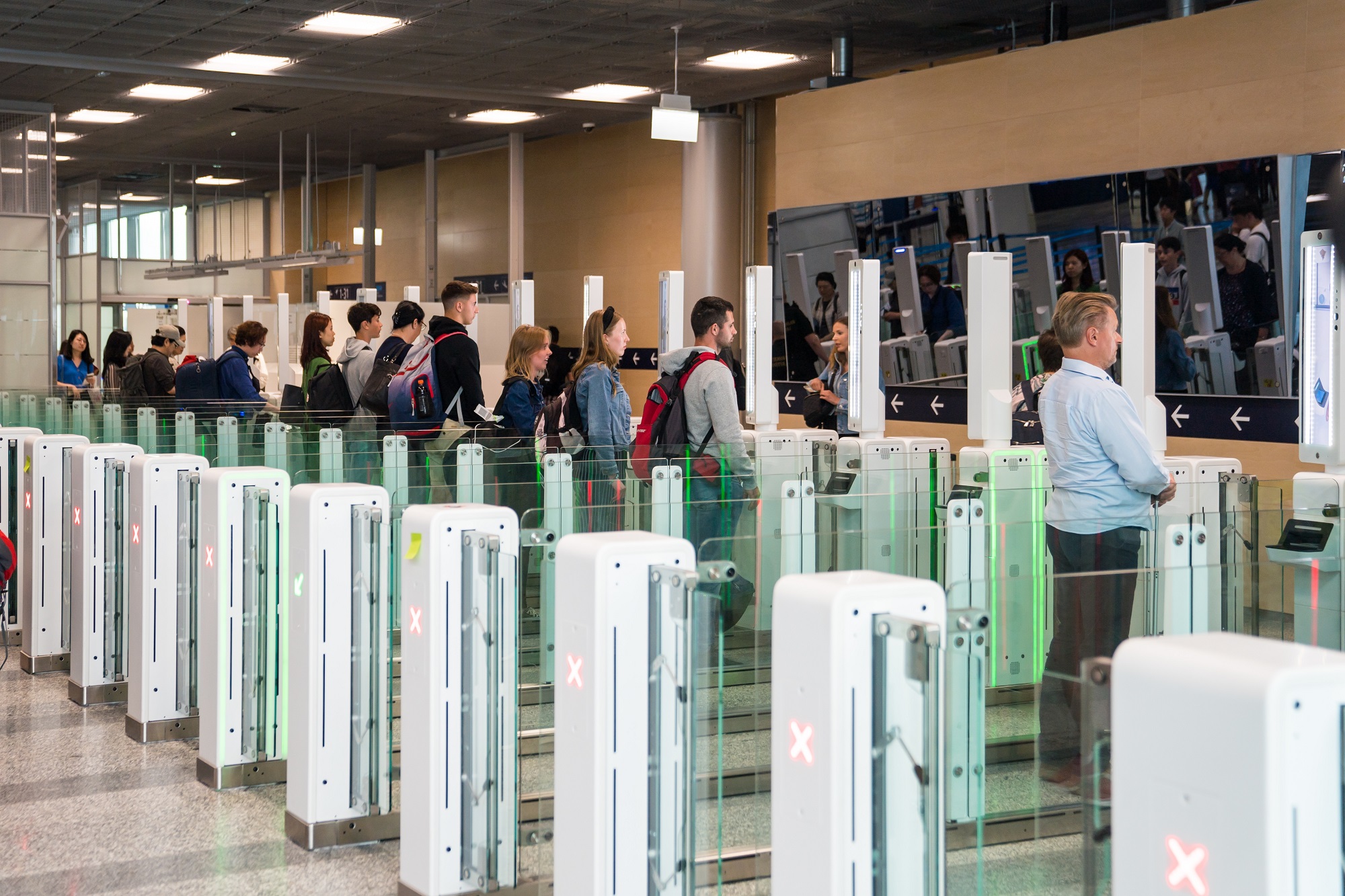 Автомат для прохождения пограничного контроля и пассажиры в аеропорту Хельсинки-Вантаа