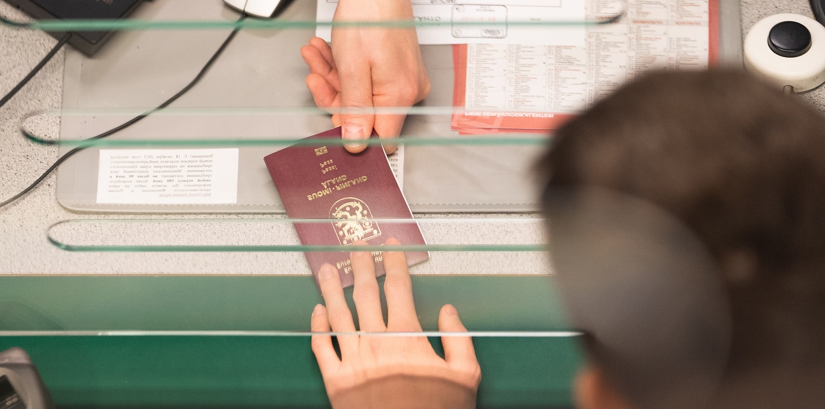 Rajavartija ojentaa passia matkustajalle.