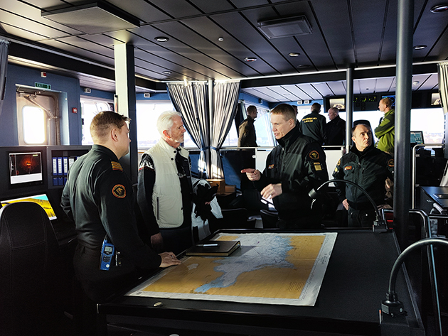 Människor runt kartbordet på kommandobryggan.