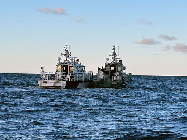 Två patrullbåtar bredvid varandra på havet.