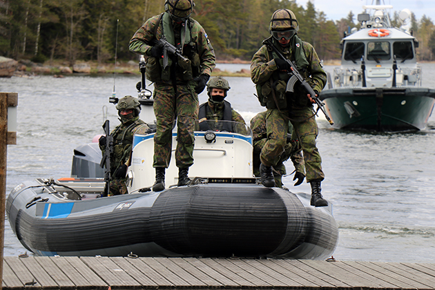 Reservister stiger upp på bryggan från en snabb båt.