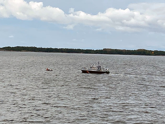 Partiovene menossa ihmisiä täynnä olevan kumiveneen luokse.