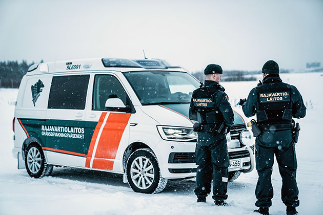 Partioauto ja kaksi merivartijaa lumisateessa.