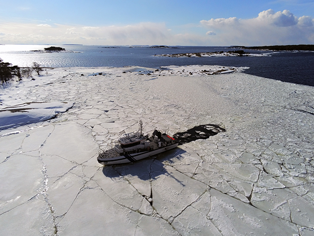En kustbevakningsbåt bland isen. I bakgrunden öppet hav.&nbsp;