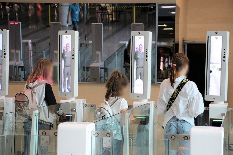 Tre personer står vid gränskontrollen.