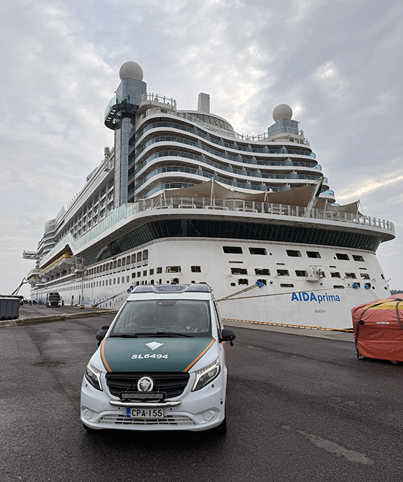 Partioauto laiturilla, taustalla risteilyalus.