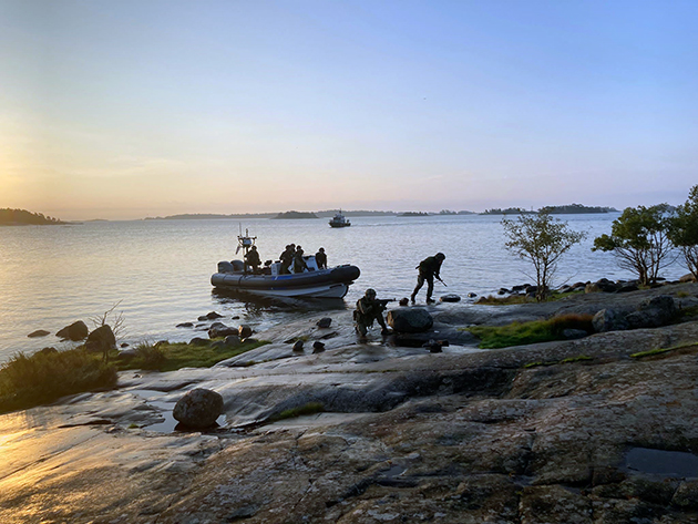 Reserviläiset nousemassa maihin nopeasta veneestä.