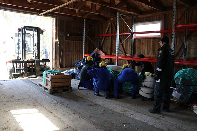 Sjöbevakare inspekterar rullar med oljebommar.