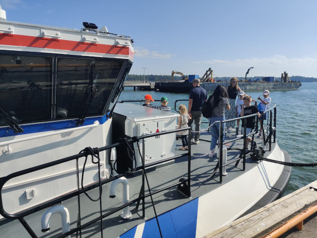 Yleisöä rannikkovartioveneen kannella.