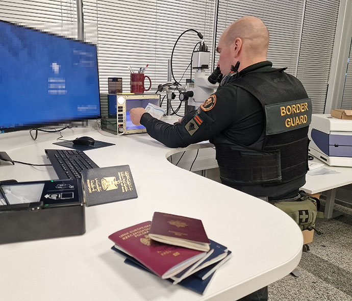 Rajavartija tutkimassa passeja.