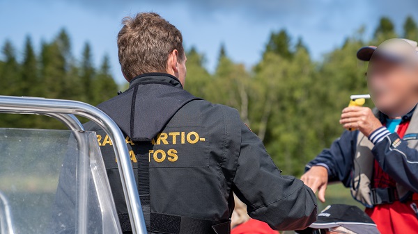 Rajavartija puhalluttaa veneen kuljettajaa.