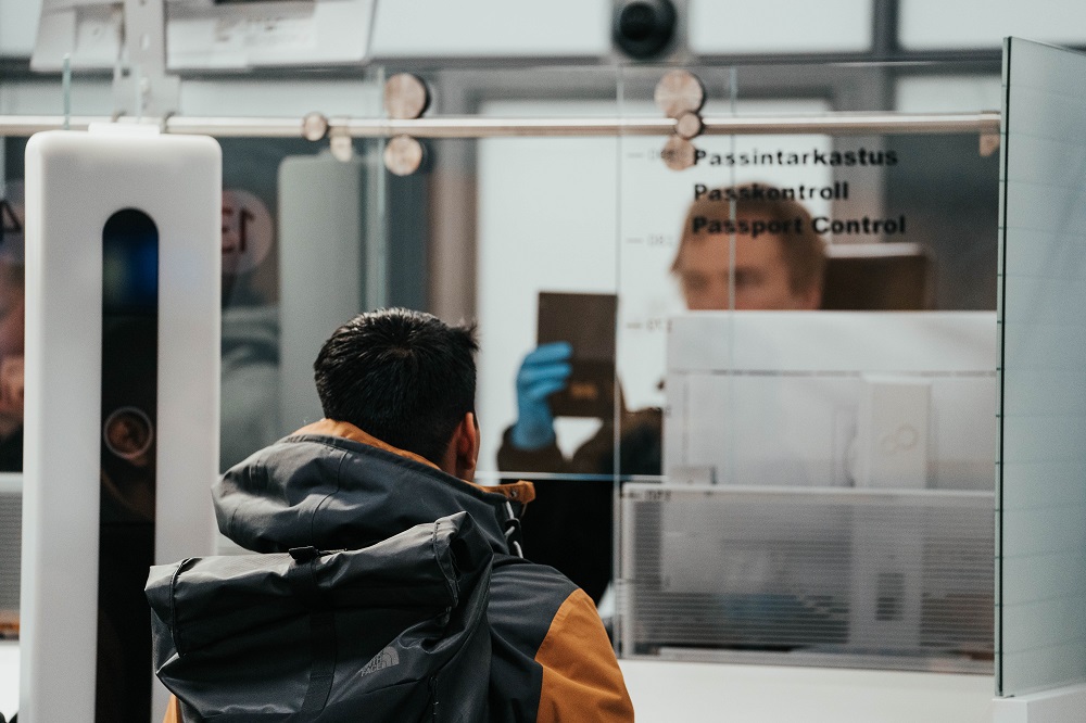 Rajavartija tarkastaa henkilön passia.