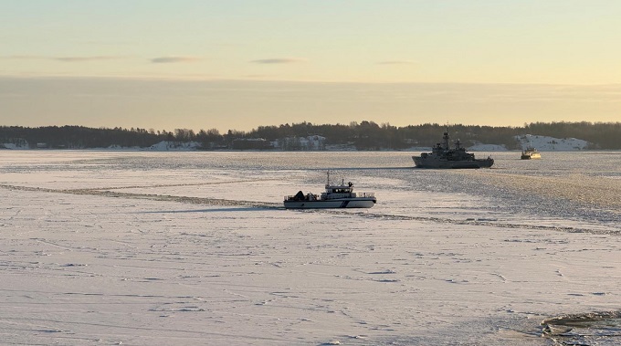 Rajavartiolaitoksen rannikkovartiovene jäisellä merellä, kuvan taustalla myös Puolustusvoimien alus ja Suomenlinnan huoltolautta.