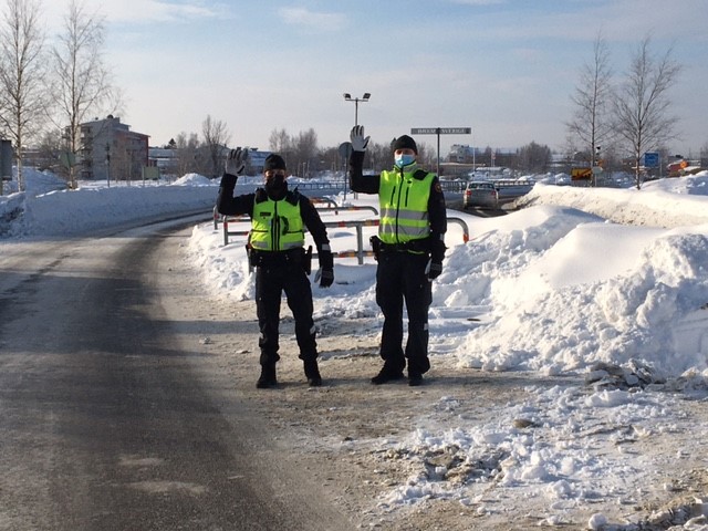 Rajavartijat seisovat tien vieressä ja heilauttavat kättä tervehdyksen merkeissä. Vieressä lumikinos.