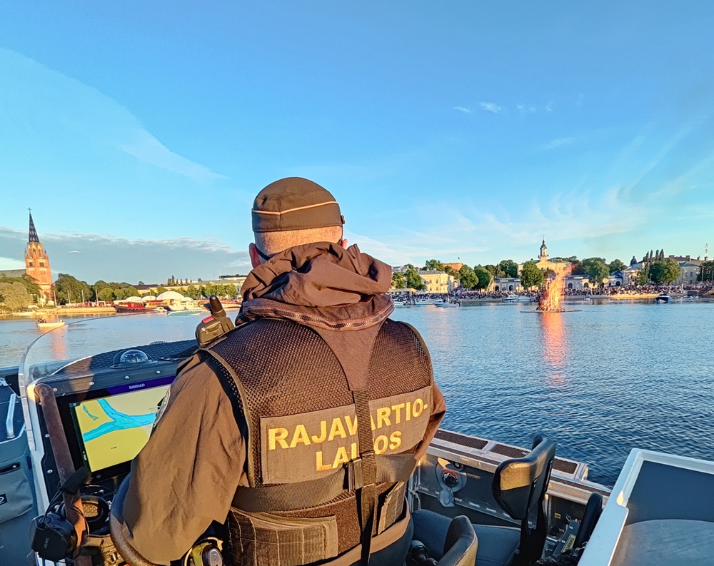 Rajavartiolaitoksen partio veneellä katsomassa palavaa kokkoa.