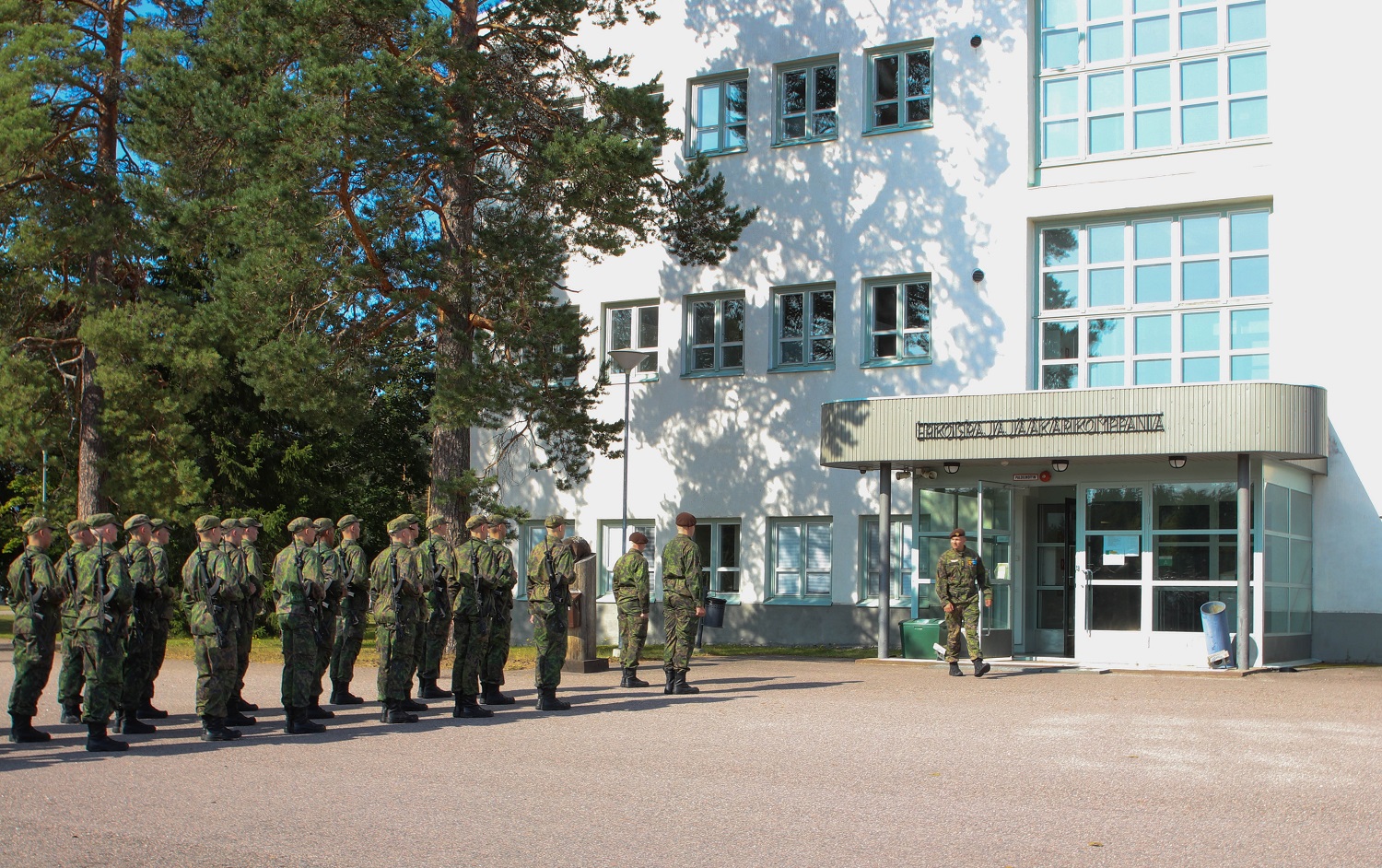 Conscripts standing in a triangle formation in front of a Special Border Jaeger Company Building.