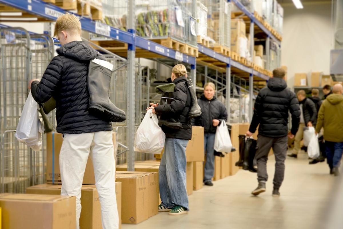 Rajavartijaopiskelijat keskusvarastolla pakkaamassa säkkeihin saappaita ja muita tarpeita.