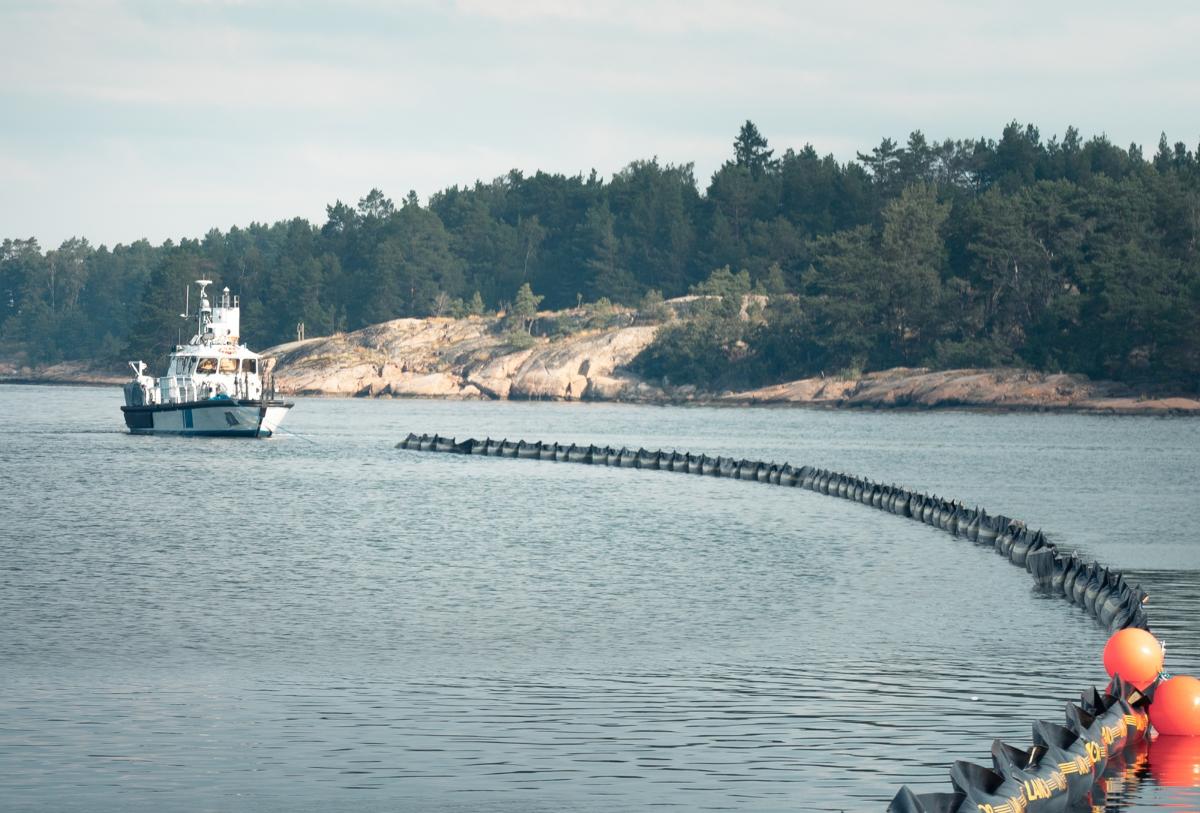 Öljyntorjuntapuomia siirretään meressä Rajavartiolaitoksen partioveneen avulla