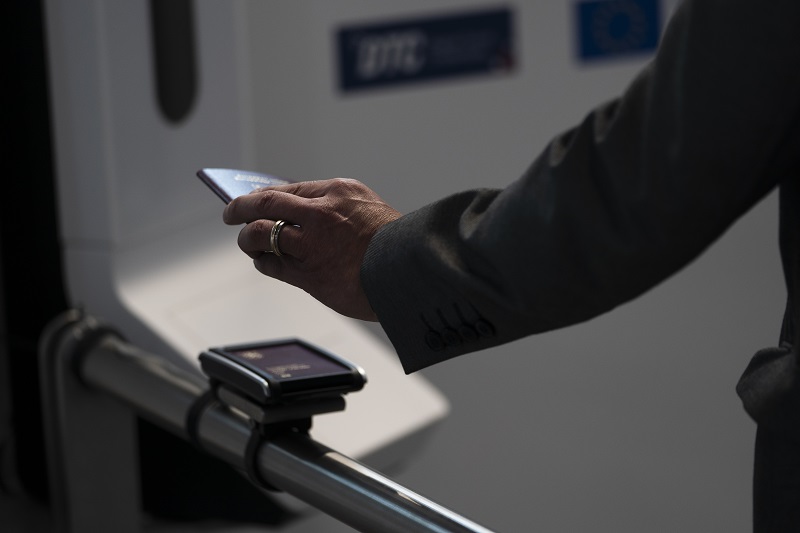 A passenger keeps his cell phone on the DTC reader.