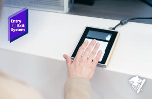 A passenger places four fingers of their right hand on a fingerprint scanner during border control.