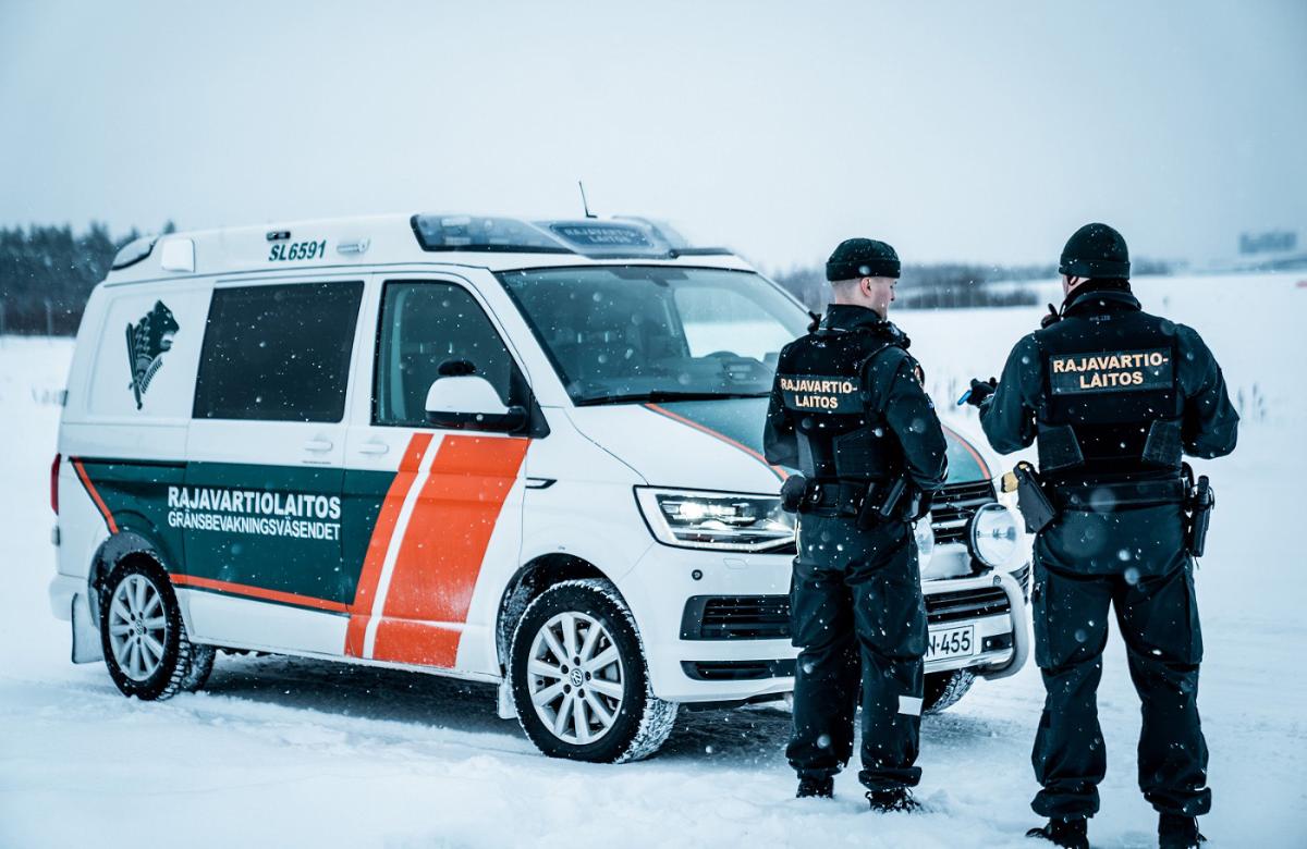 Two border guards and a patrol vehicle on winter.