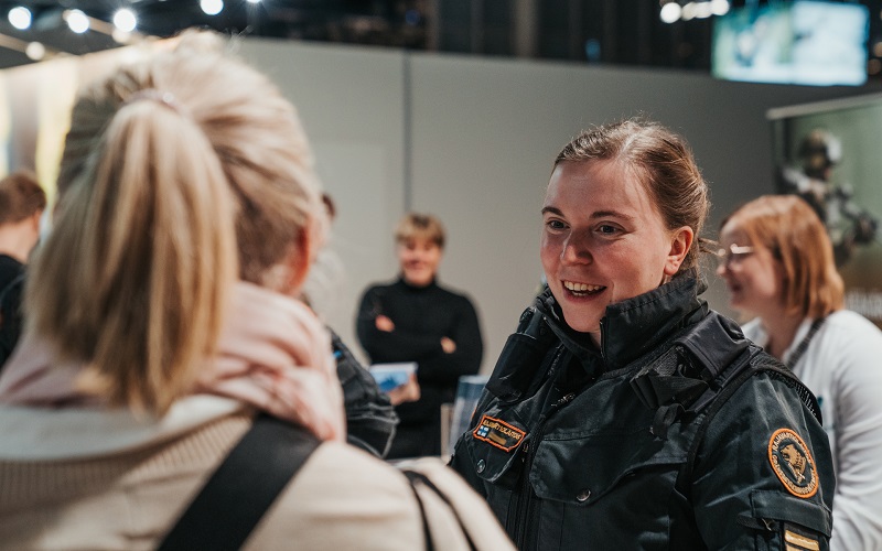 Rajavartija keskustelee messuvieraan kanssa.