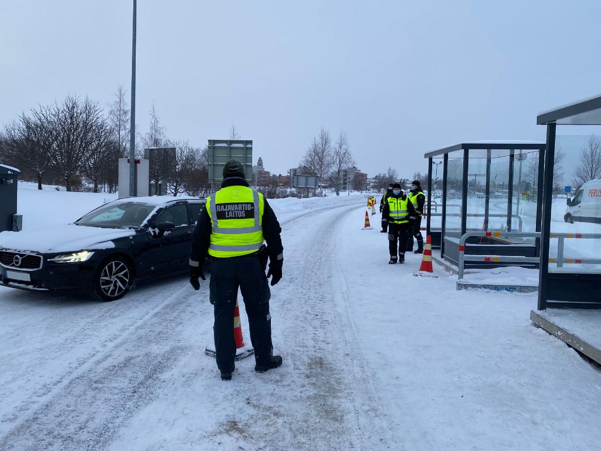 Gränsbevakare jobbar utomhus. En bil har anlänt till gränskontrollen.