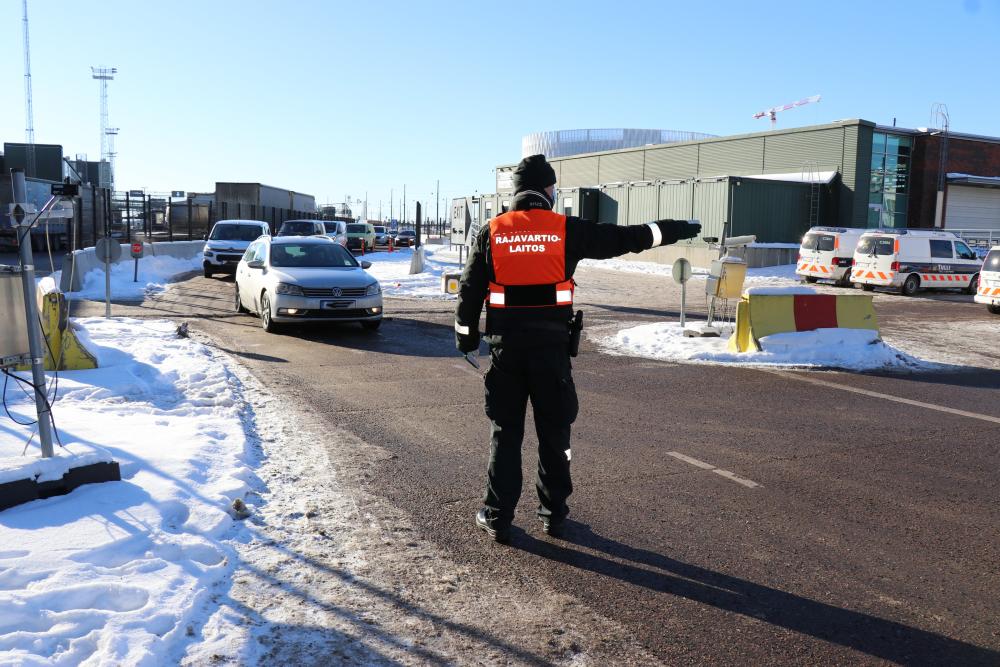 Gränsbevakaren styr bilar i hamnen.