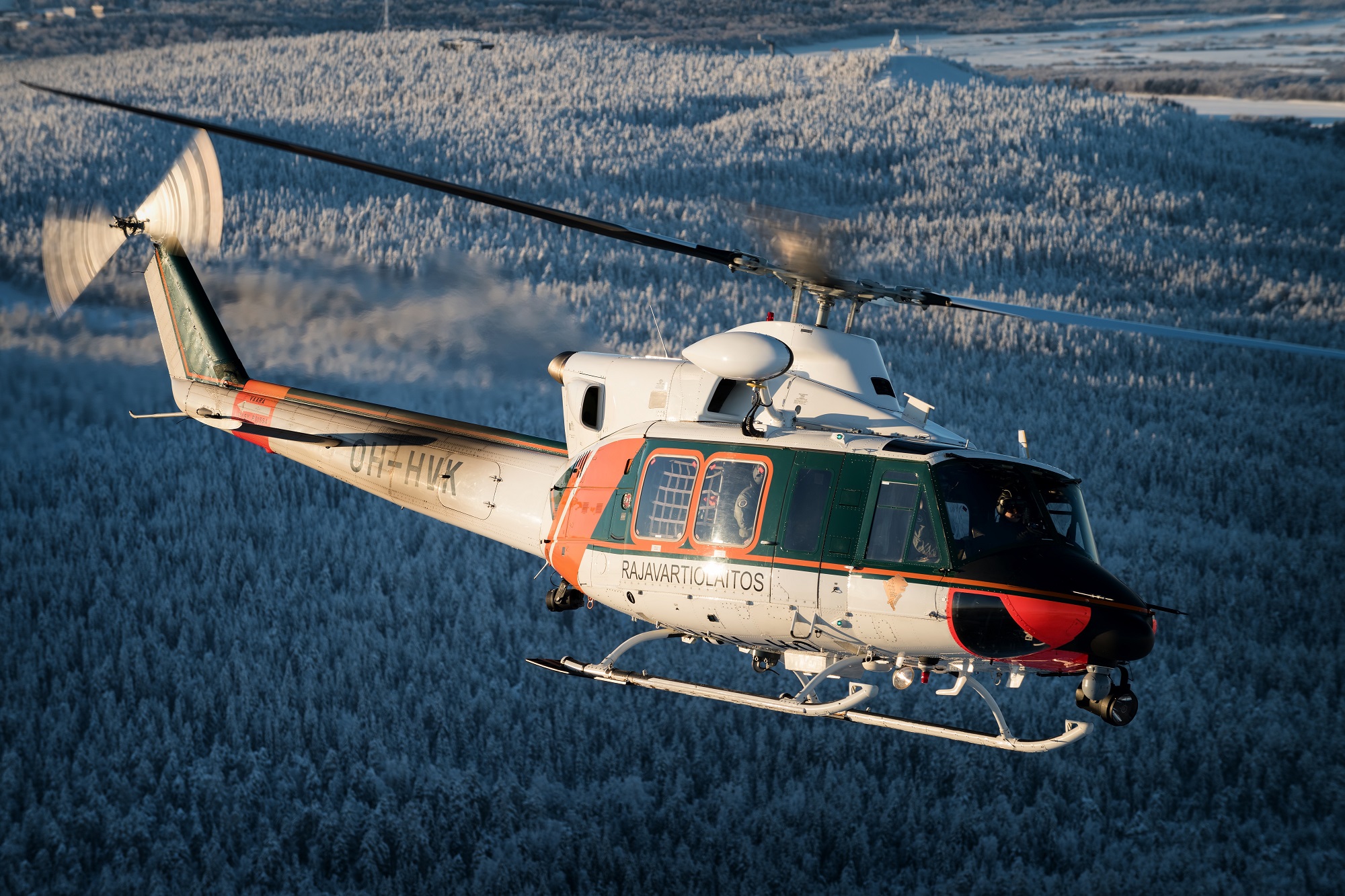 ABB-helikopteri lentämässä lumisessa maisemassa.