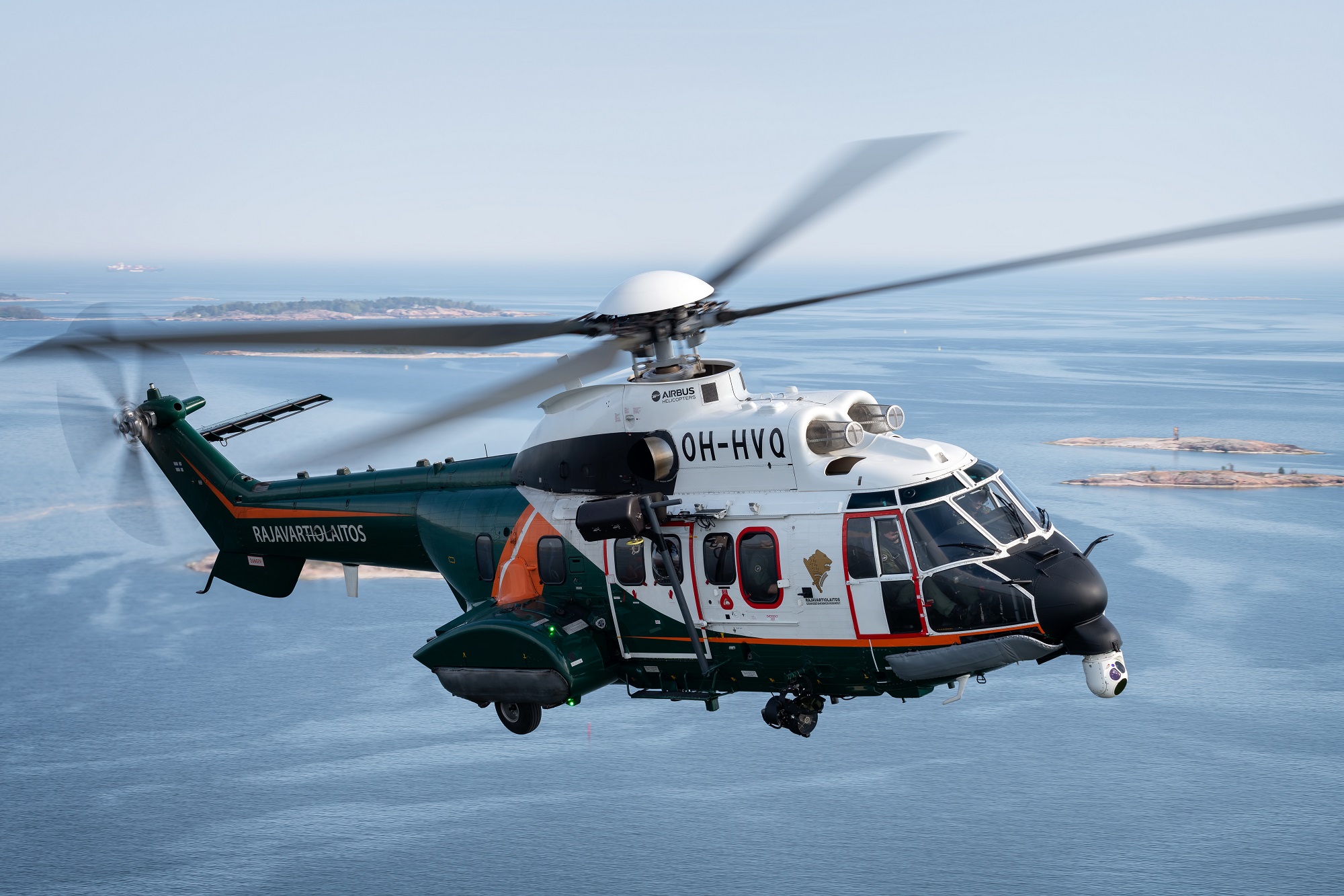 Super Puma -helikopteri lentää rannikon yllä.