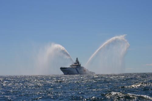 Bevakningsfartyget Turva på havet med vattenkanonerna på.