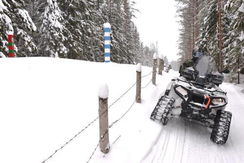 En traktorfyrhjuling med rullband i snön på patrulluppdrag i gränszonen.